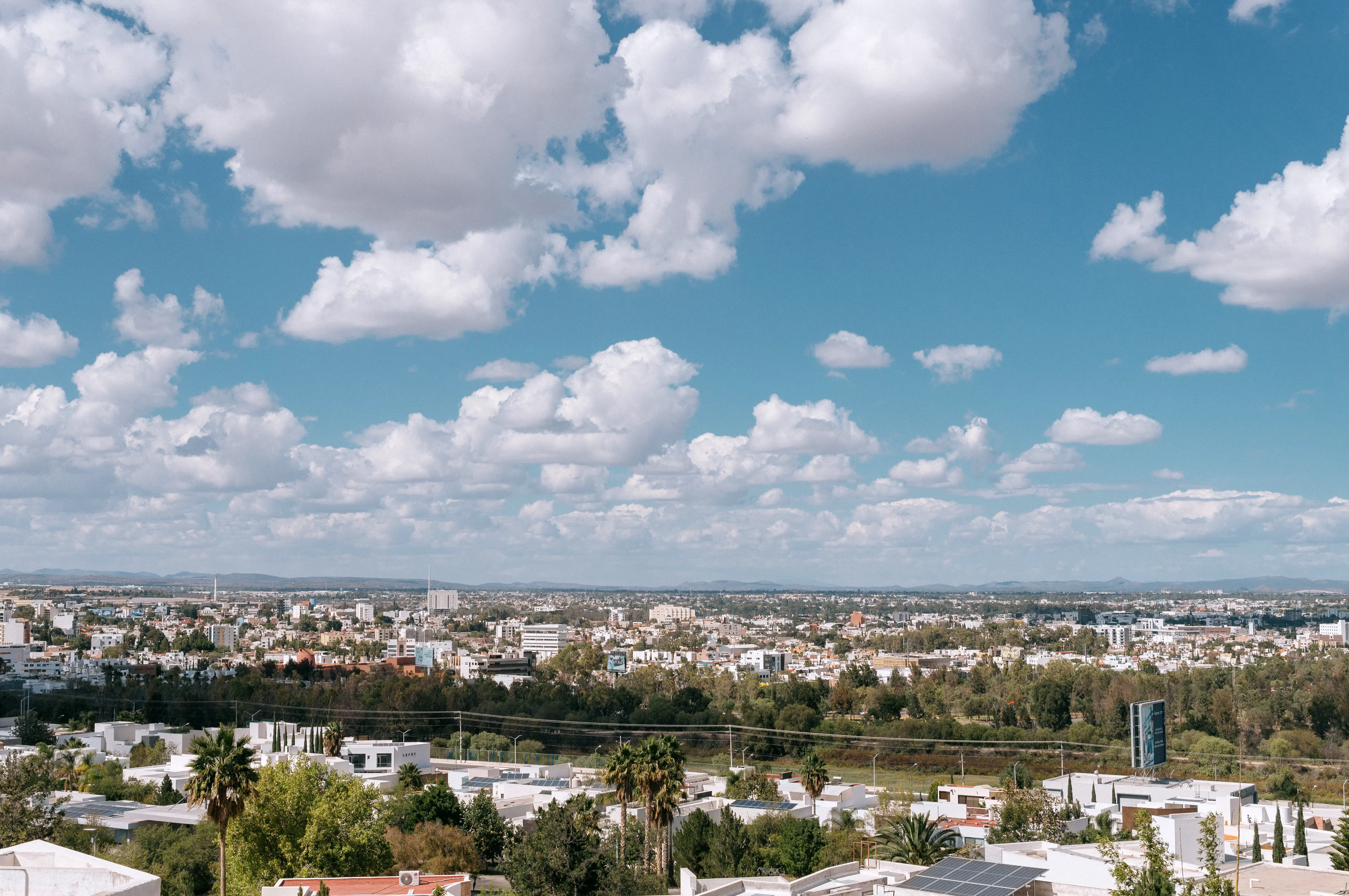 Sol vespertino sobre San Luis Potosí. Vista panorámica de la ciudad con un gran cielo azul y nuboso