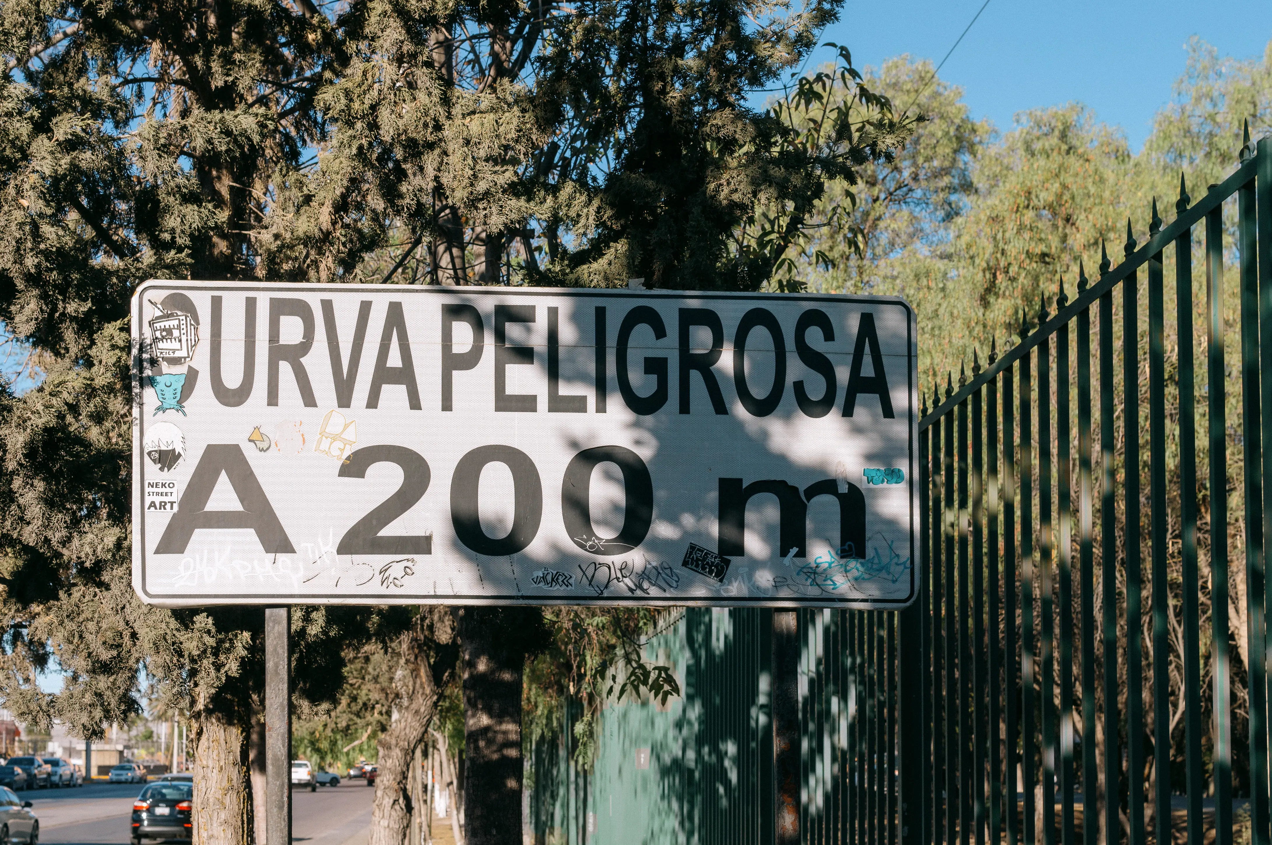 Cartel urbano que advierte de una curva peligrosa