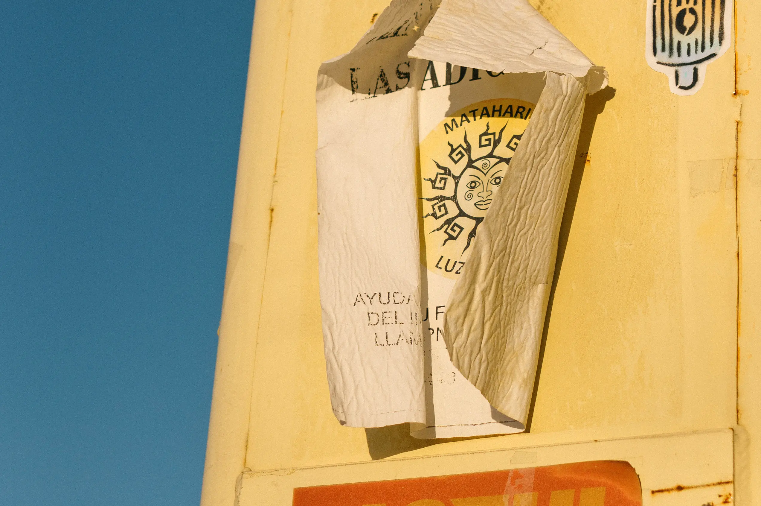 Vista detalle de un cartel callejero pegado sobre un poste de luz. Parece ser sobre un centro terapéutico extraño