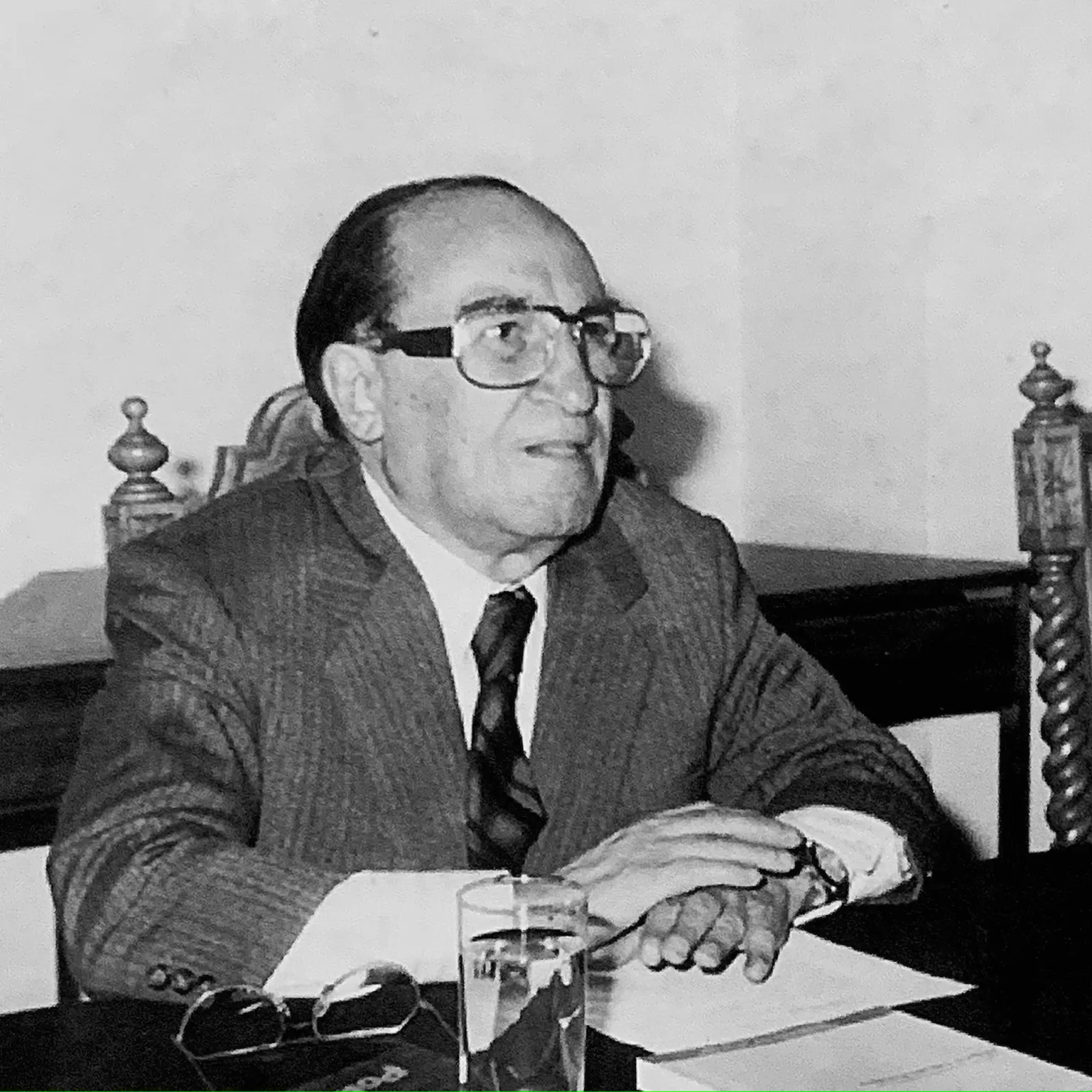 Retrato a blanco y negro de Peñalosa, sentado, en una junta dentro de la Universidad Autónoma de San Luis Potosí